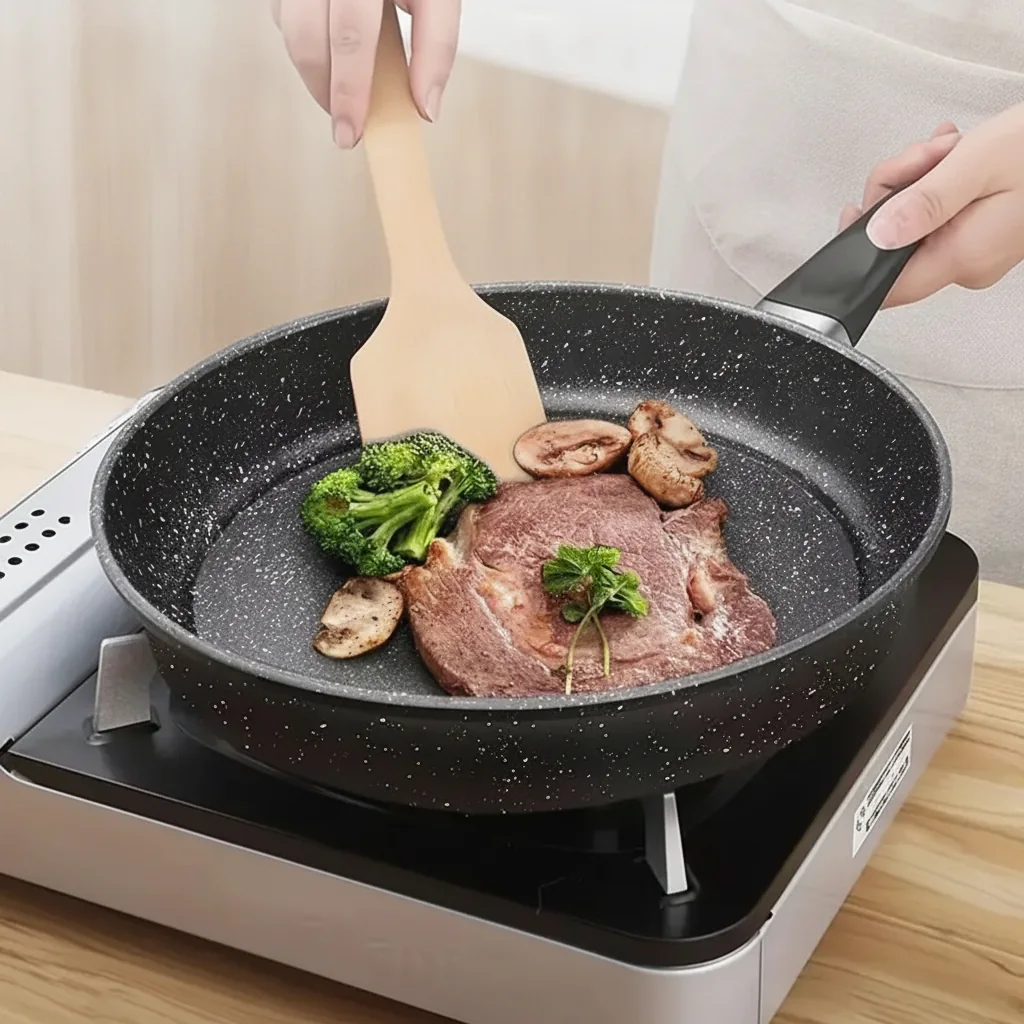 Padella antiaderente nera 26 cm, effetto pietra, gas, elettrico e induzione 1 Steak et champignons dans la poêle noire antiadhésive sur une plaque de cuisson